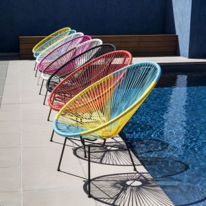 colorful acapulco chair next to the swimming pool