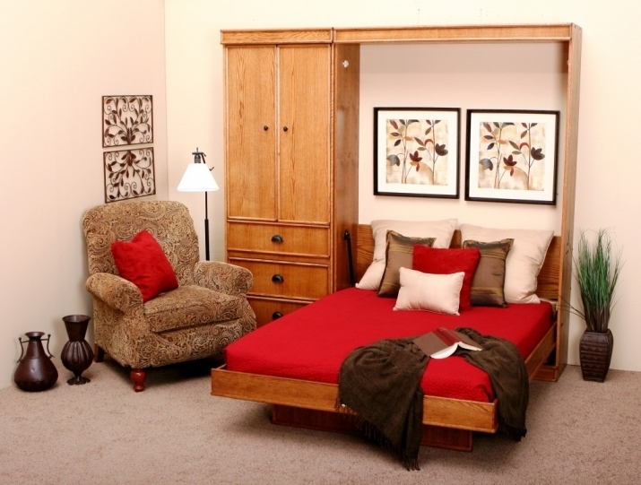 red wooden wall bed in a cabinet