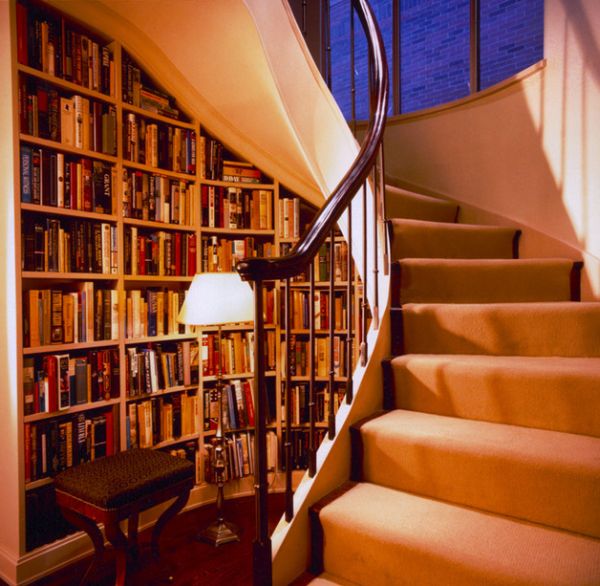 warm library space underneath a spiral staircase storage space concept
