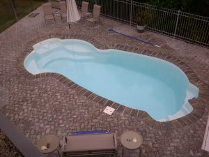 fiberglass inground pool installed in a backyard