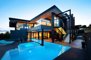 modern glass house with swimming pool view at night