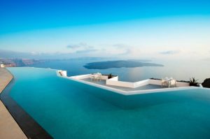 Greece Santorini rooftop infinity pool overlooking the open sea and deep blue sky