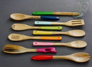 colorful kitchen utensils dipping in multiple paints