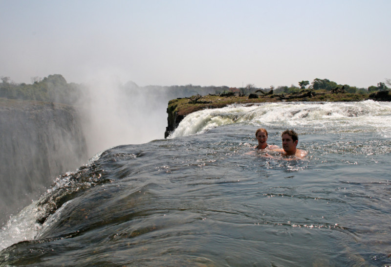 natural infinity pool at victoria fall with tourist swimming to the edge